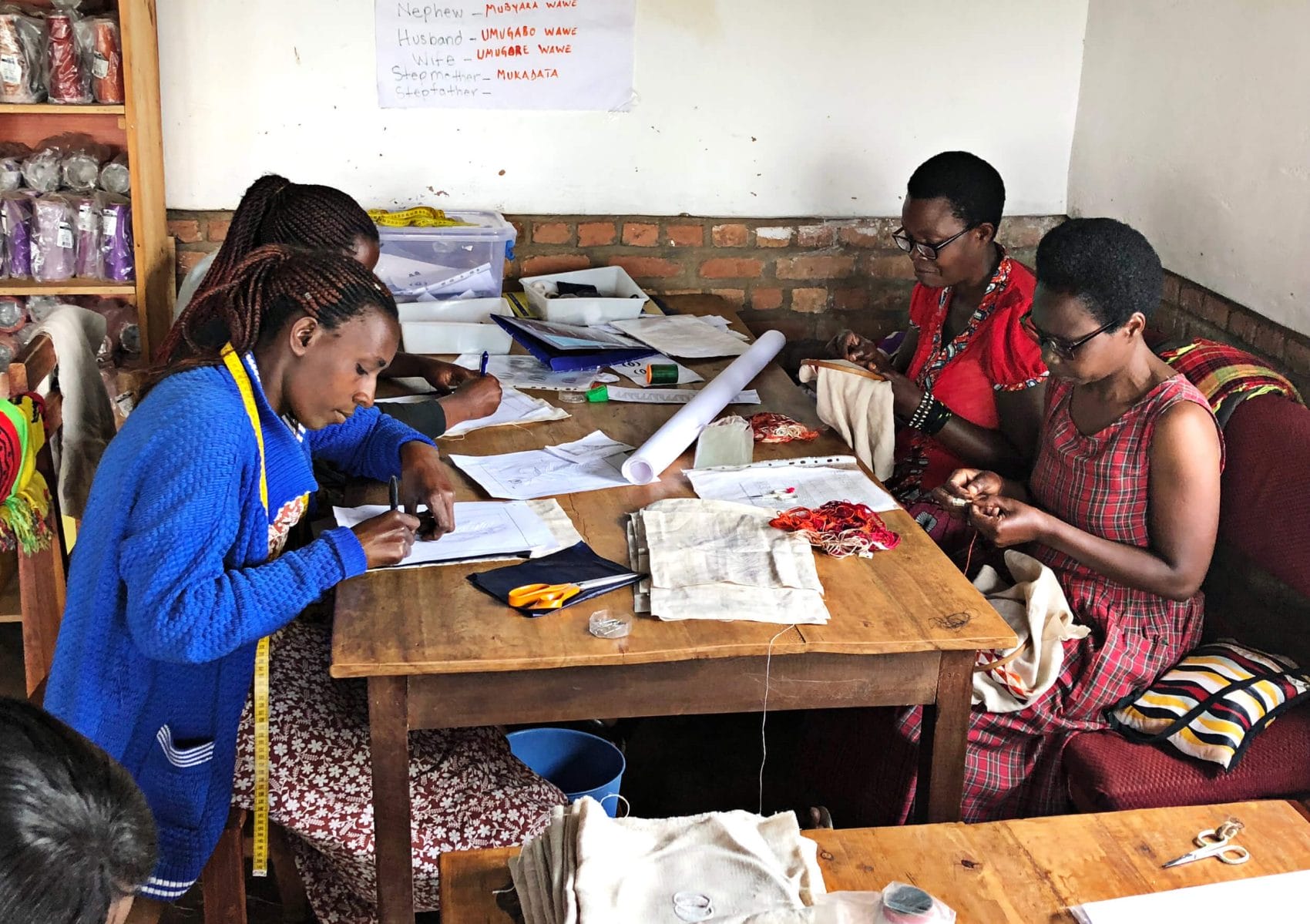 women-of-ibaba-working Four Ibaba employees make hand-embroidered gifts at a table