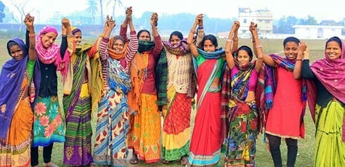 women in colorful closing celebrating with arms raised
