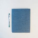 closed blue portfolio with pen