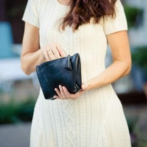 Woman in white dress holding black clutch