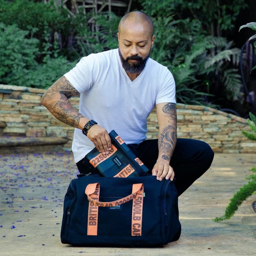 A model places a branded logo bag into a larger branded logo bag.