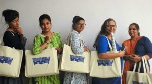 Five women model the bulk reusable shopping bags they had a hand in creating