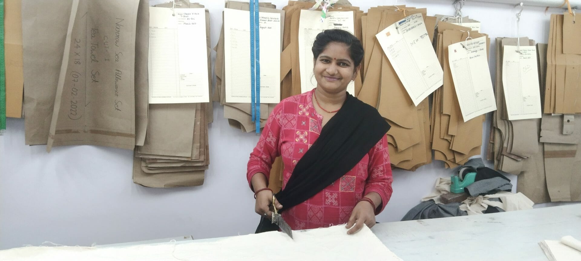 Seema, who helped to make Levi's reusable shopping bags bulk, smiles at her cutting station