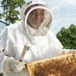 Your Breakfast Joy corporate coffee gifts include BeeLove honey, made by beekeepers like the man shown.