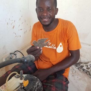 A craftsman displays a dove ornament, one of our holiday gifts from Haiti