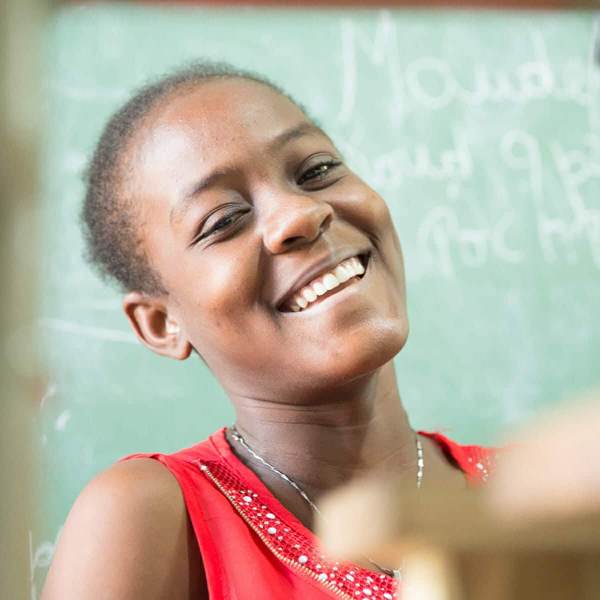 Our leather office gifts are created by workers at Deux Mains, like the woman shown smiling here.