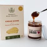 Scones and jam gift basket with spoon above open jam