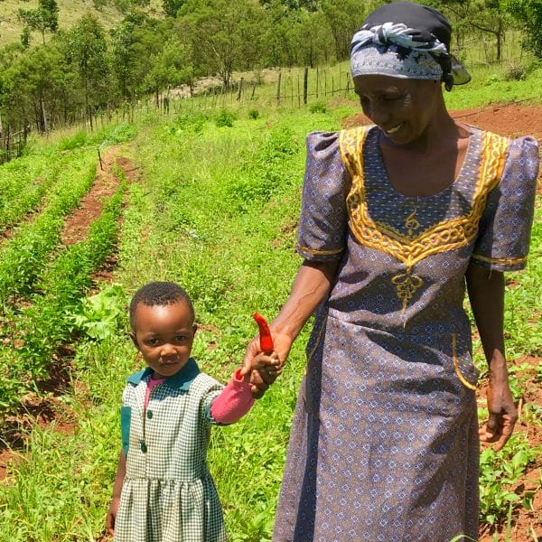 Your condiment gift set is made with ingredients grown in Eswatini by women farmers like the one pictured here with her young daughter in a field.