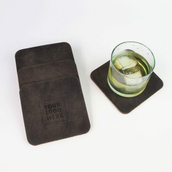 Set of leather coasters with logo and a rocks glass