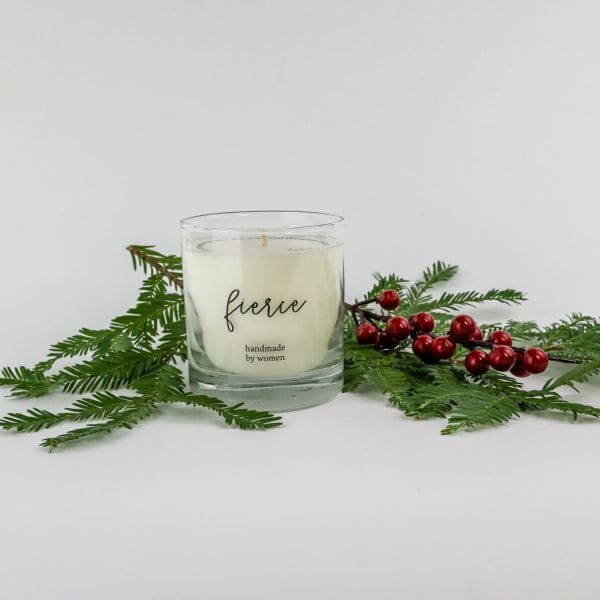 One of our motivational candles for employees with a pine branch and holiday berries