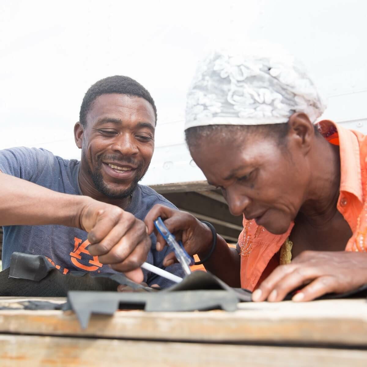 Two workers create sustainable tech gifts from salvaged materials