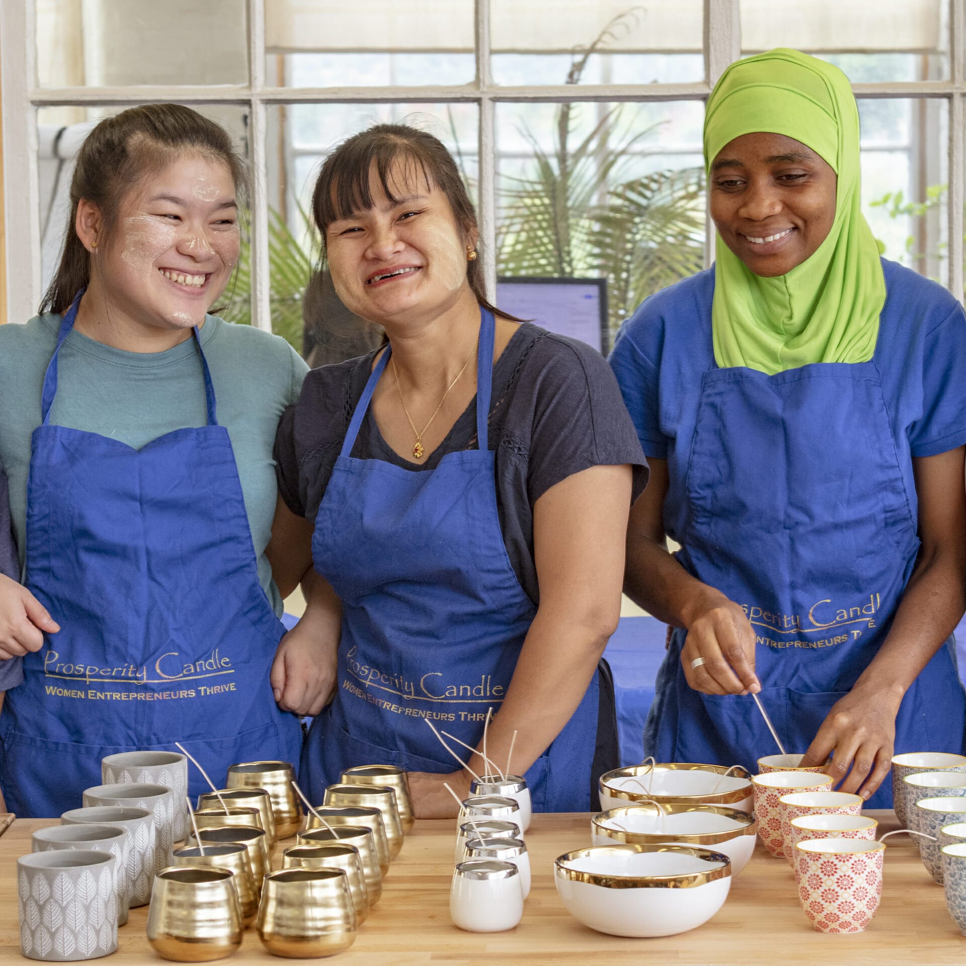 Three women create candles for a good cause