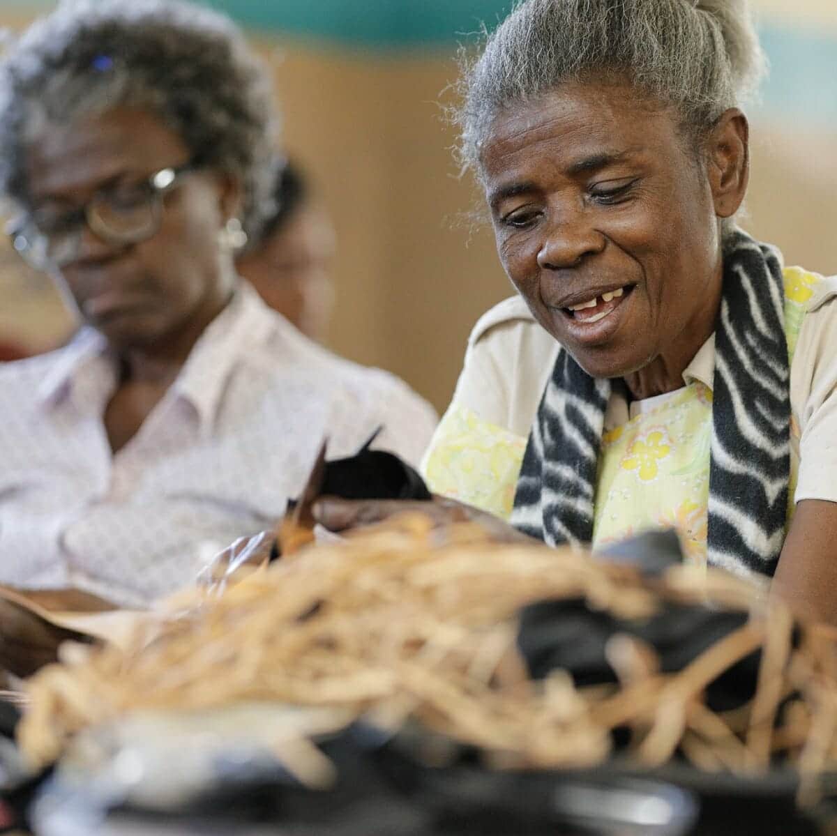 Two women work to create leather gifts from Haiti