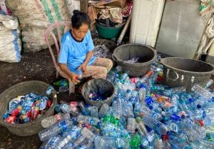 A woman in Bali sorts plastic bottles that will become sustainable employee gifts