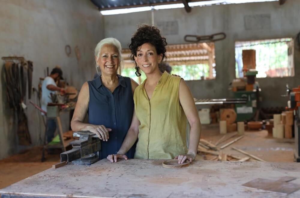 two smiling women at workbench
